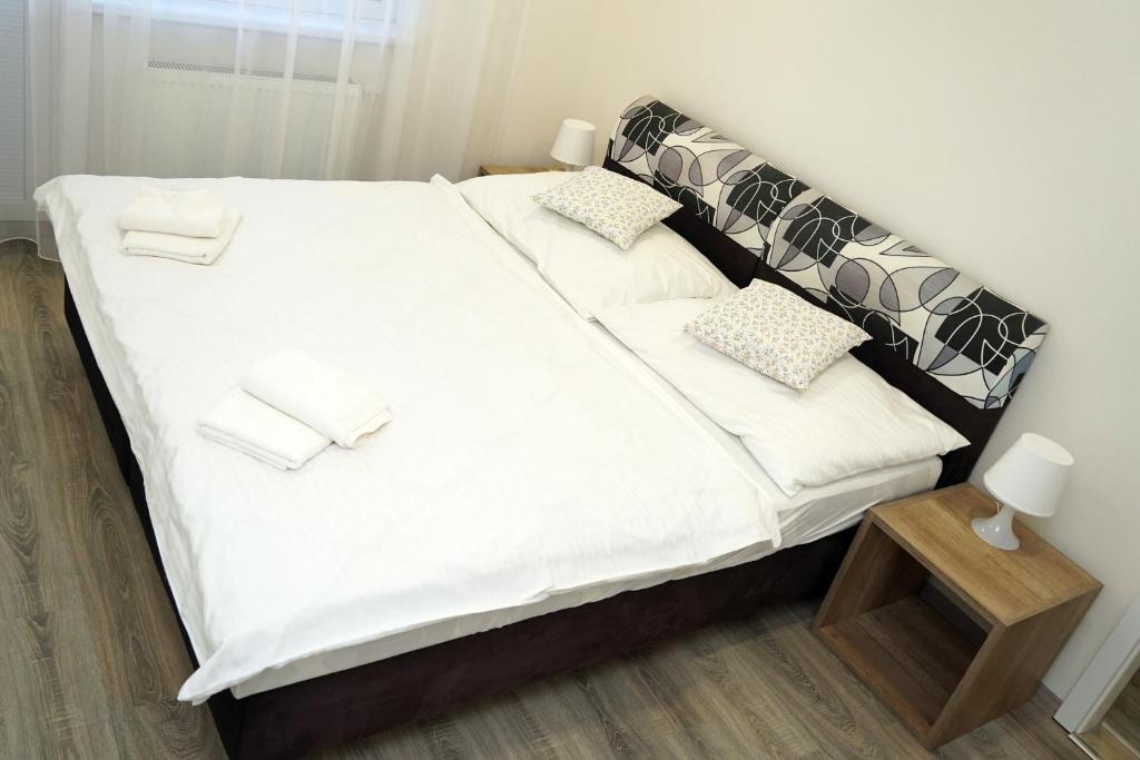 a large bed with white sheets and pillows at Panorama Motel -Wellness in Veľký Meder