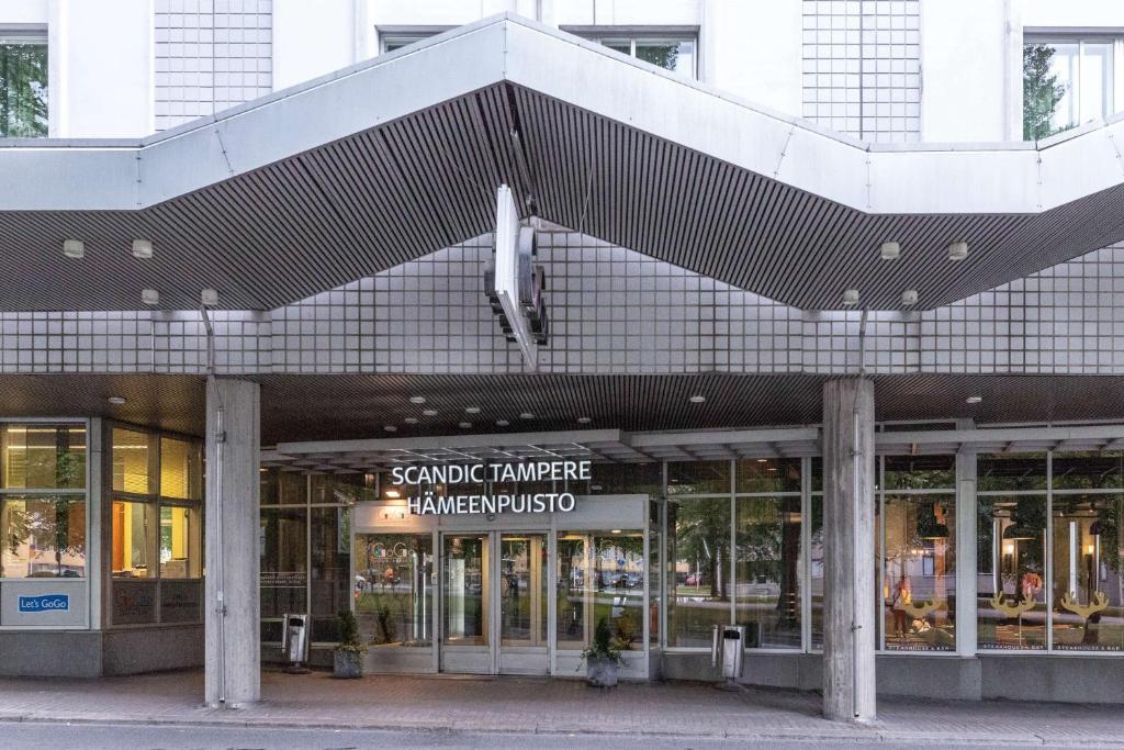 a building with awning over the entrance to a store at Scandic Tampere Hämeenpuisto in Tampere