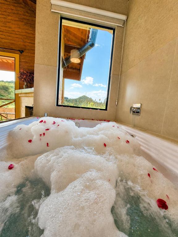 a room with a bath tub covered in snow at Chalé Som da Sete Quedas Hidromassagem, Lareira e Vista para as Montanhas in Gonçalves