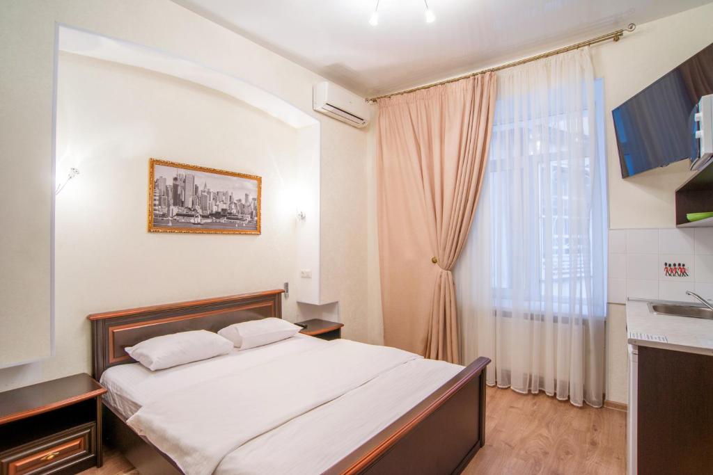 a bedroom with a bed and a large window at Soprano Apart Hotel in Odesa