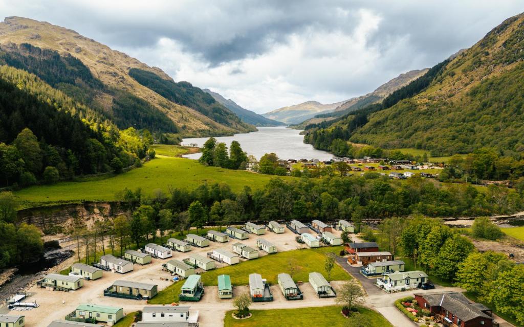 an aerial view of a village with a river and mountains at Stratheck Holiday Park in Dunoon