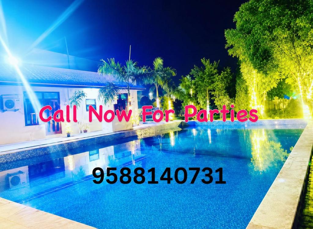 a picture of a swimming pool at night at Aravali view Farmhouse in Gurgaon