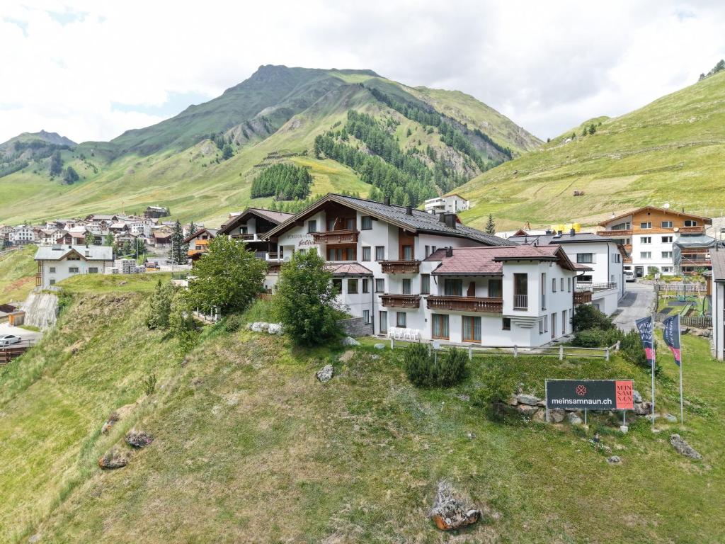 a village on a hill with mountains in the background at Soliva Hotel & Apartments by MEIN SAMNAUN - MOUNTAIN HOMES in Samnaun