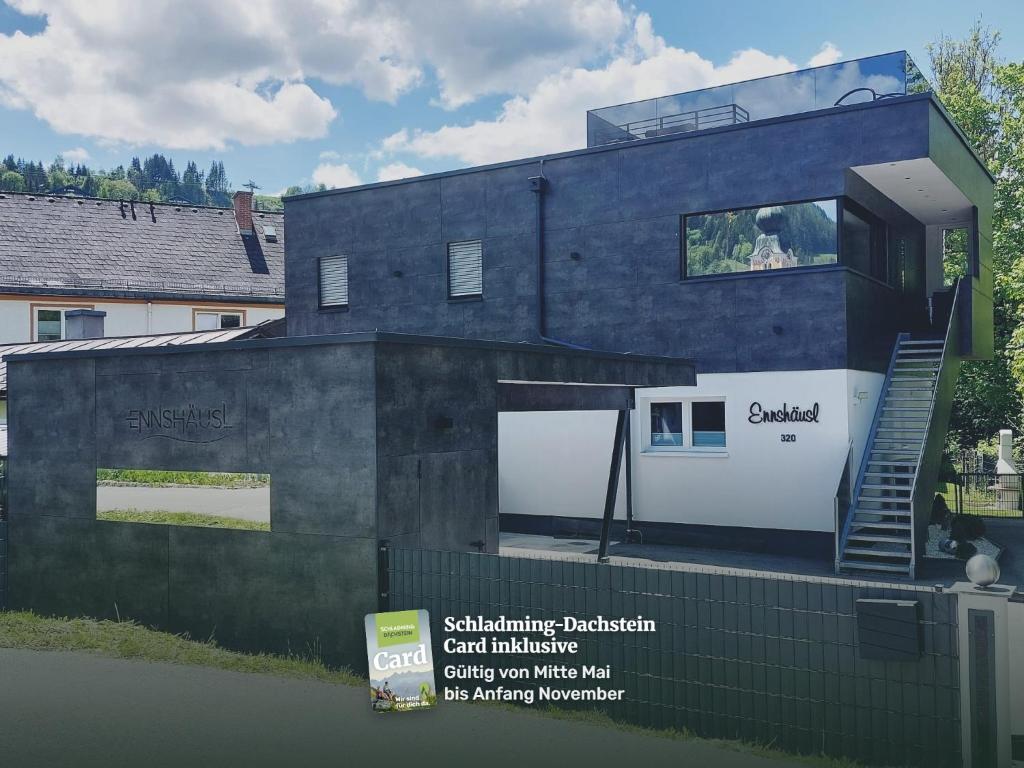 a black house with a sign in front of it at Ennshäusl by Schladming-Appartements in Schladming
