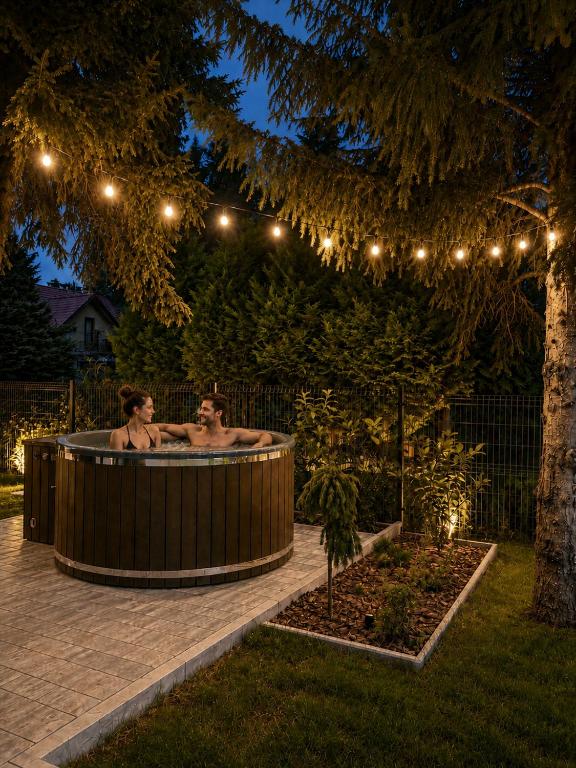 two men in a hot tub in a garden at night at oto harmonia in Rąbinek