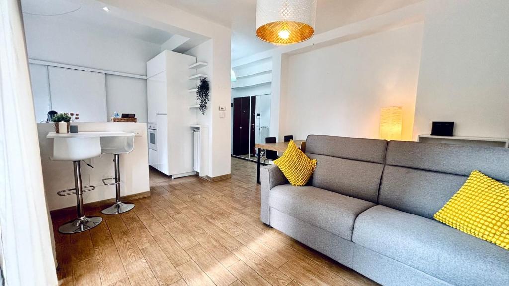a living room with a couch and a kitchen at BorgoLuce Spacious Apt - FREE Parking - Near Airport & Center in Bergamo