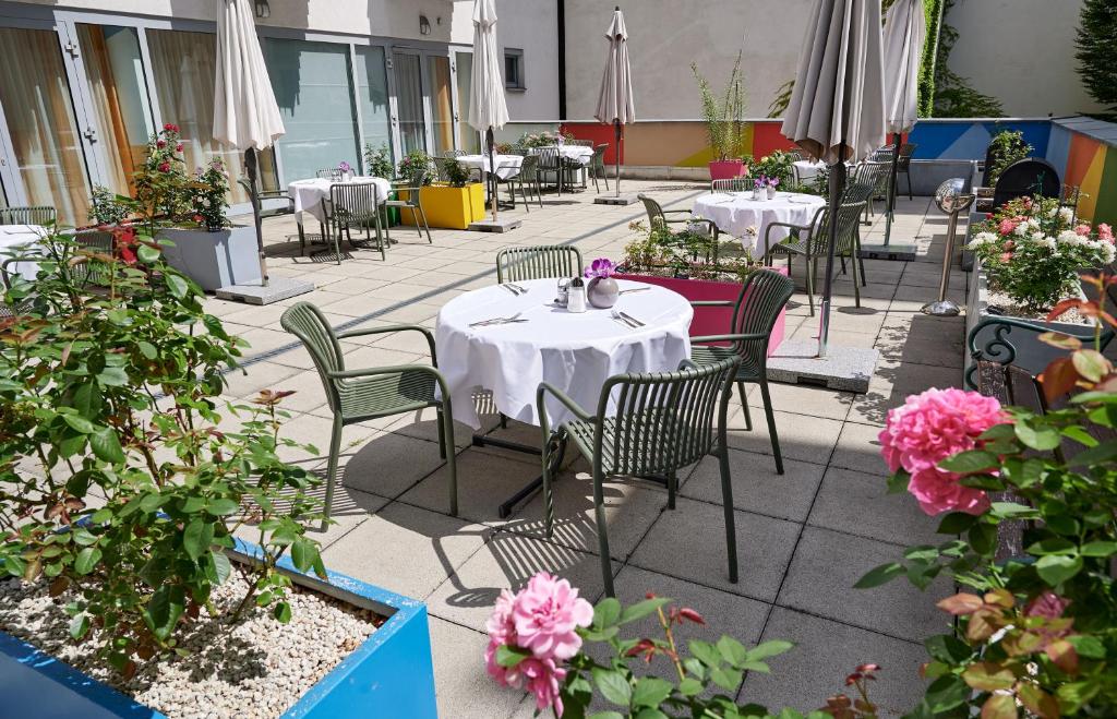 a patio with tables and chairs and flowers at Hotel Kolping Wien Zentral in Vienna