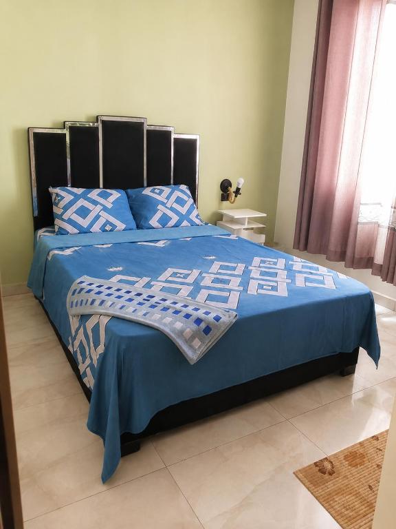 a bedroom with a bed with a blue comforter at Florida Palace Hostal in Samaipata