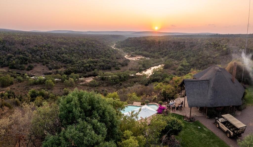 an aerial view of a house with a pool and the sunset at Magari Safari Lodge in Vaalwater