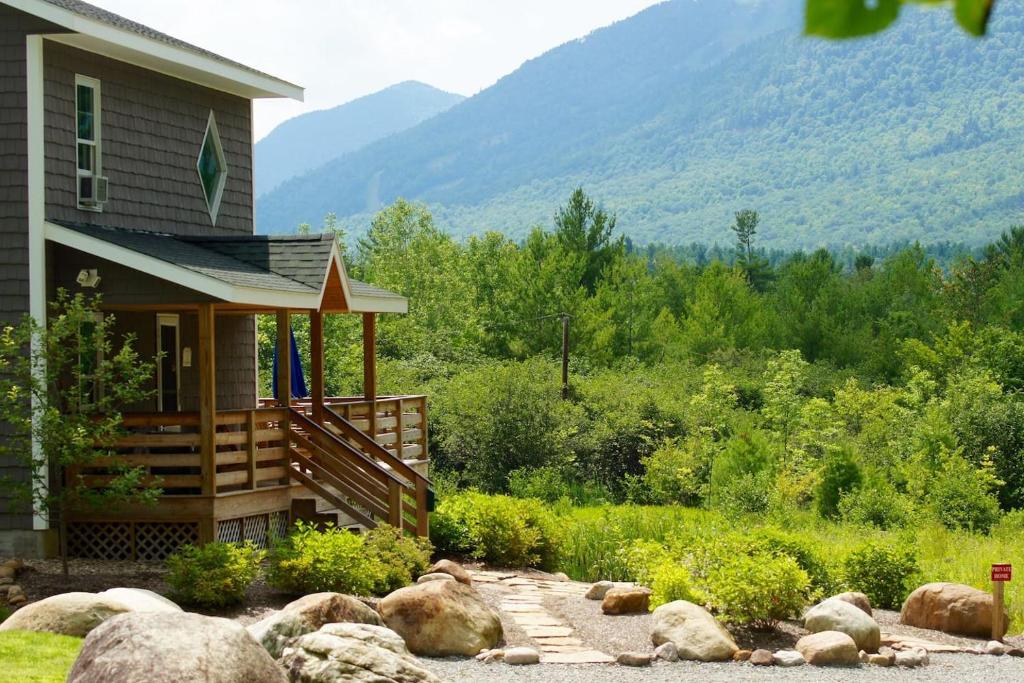 a house with a porch next to a mountain at Stunning Views, Luxury, Near Whiteface,Lake Placid in Wilmington