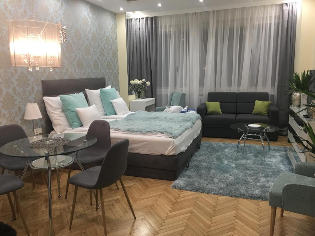 a bedroom with a bed and a couch and a table at Paloma Apartment in Budapest