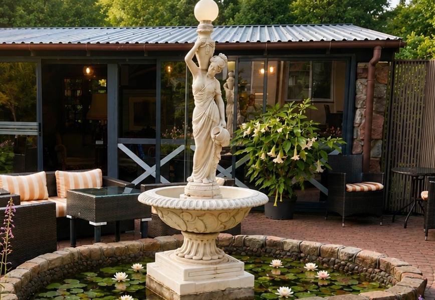 a statue of a woman standing in a fountain at Vila Florena Garden in Palanga