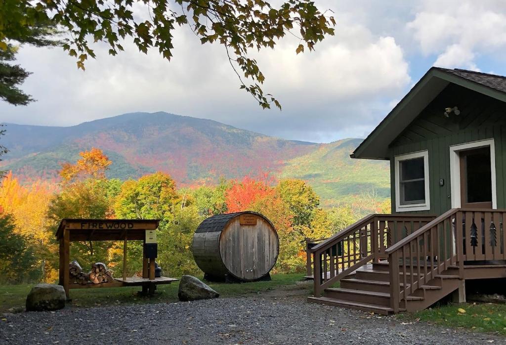 a cabin with a barrel next to a building at Breathtaking Views Near Lake Placid and Whiteface in Wilmington
