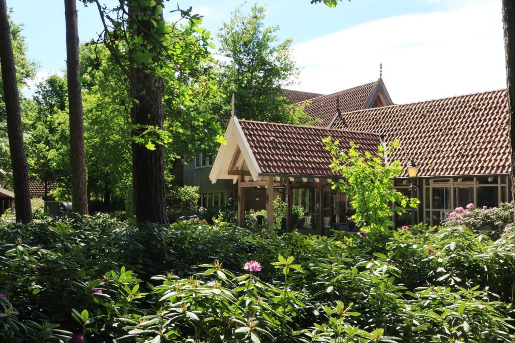 a garden in front of a house with trees at Landgoed De Holtweijde in Lattrop