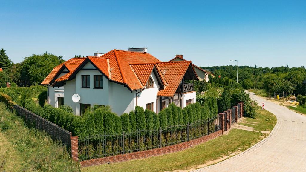 a house with a fence next to a road at Biały Dom in Gdańsk