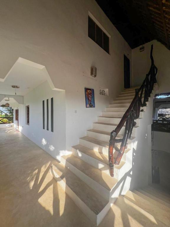 a staircase in a white building with a stair railing at Mepoho Beach Villa Watamu in Watamu