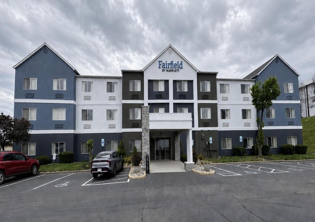 a large building with a car parked in a parking lot at Fairfield By Marriott Middletown Monroe in Middletown