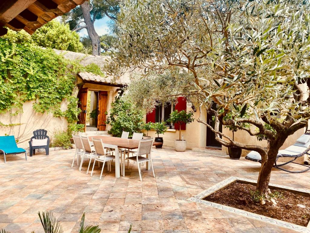 a patio with a table and chairs and a tree at Le patio Provençal-Maison avec cour privée in Nîmes