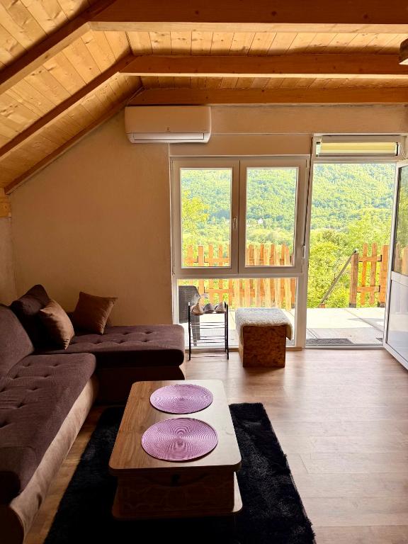 a living room with a couch and a table at Montenegro pines in Bistrica Lipovska