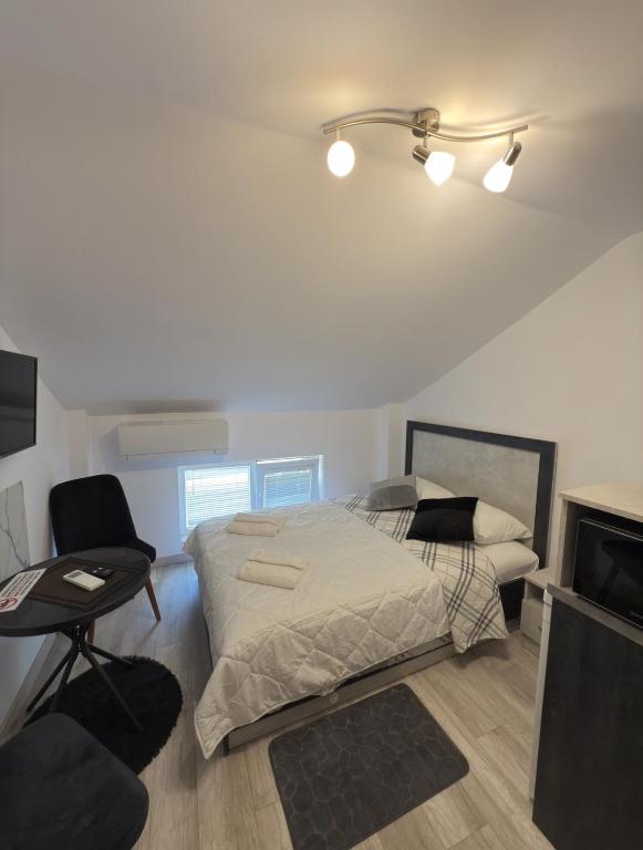 a bedroom with a bed and a chair and a tv at Storm in Varna City