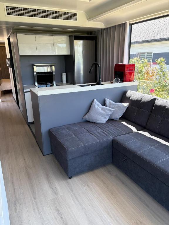 a living room with a couch and a kitchen at Capsule house for rent at Gut Holtmann in Billerbeck