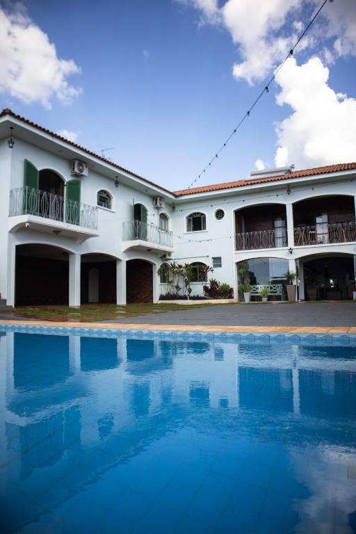 a building with a swimming pool in front of it at Dom Ravello in Telêmaco Borba