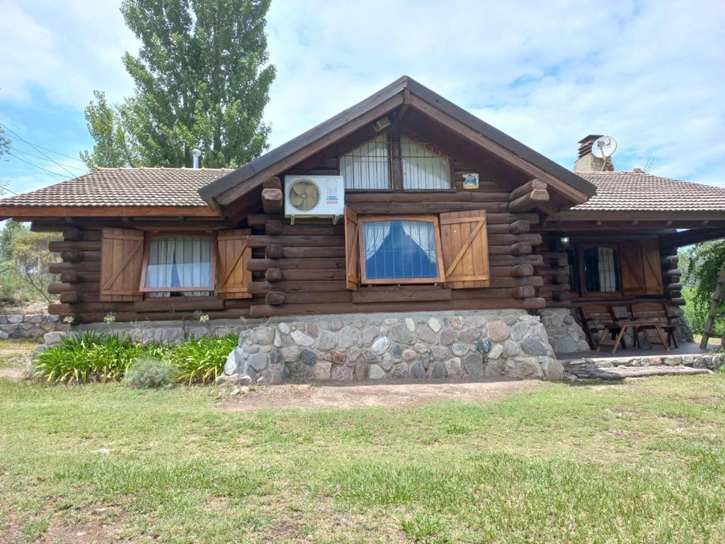 a log cabin with a porch and windows at El Rancho in Villa Giardino