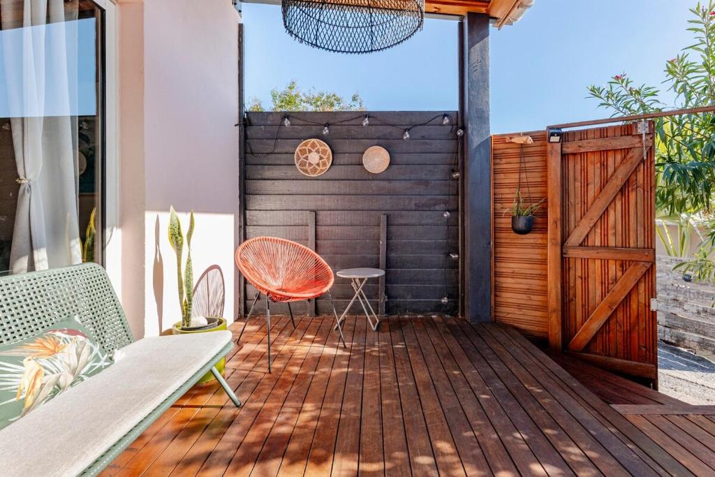 a patio with a wooden door and a chair at KAZUBUNTU in Saint-Leu