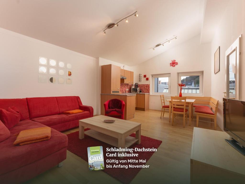a living room with a red couch and a table at Appartements Maria Stewart by Schladming-Appartements in Schladming