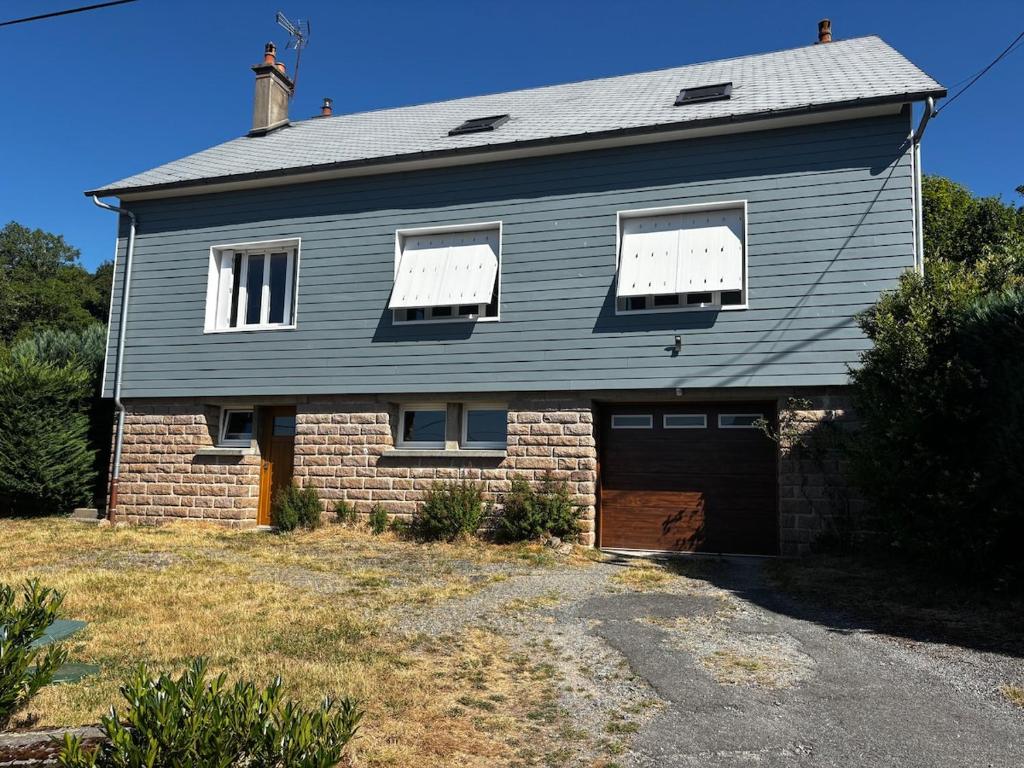 a large house with a garage in front of it at Maison familiale 10 pers à St Setiers in Saint-Setiers
