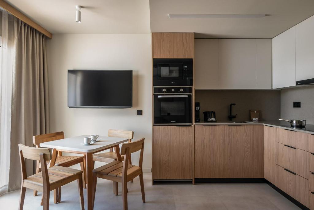 a kitchen with a table and chairs and a kitchen with a tv at Apartamentos Estival Park in La Pineda