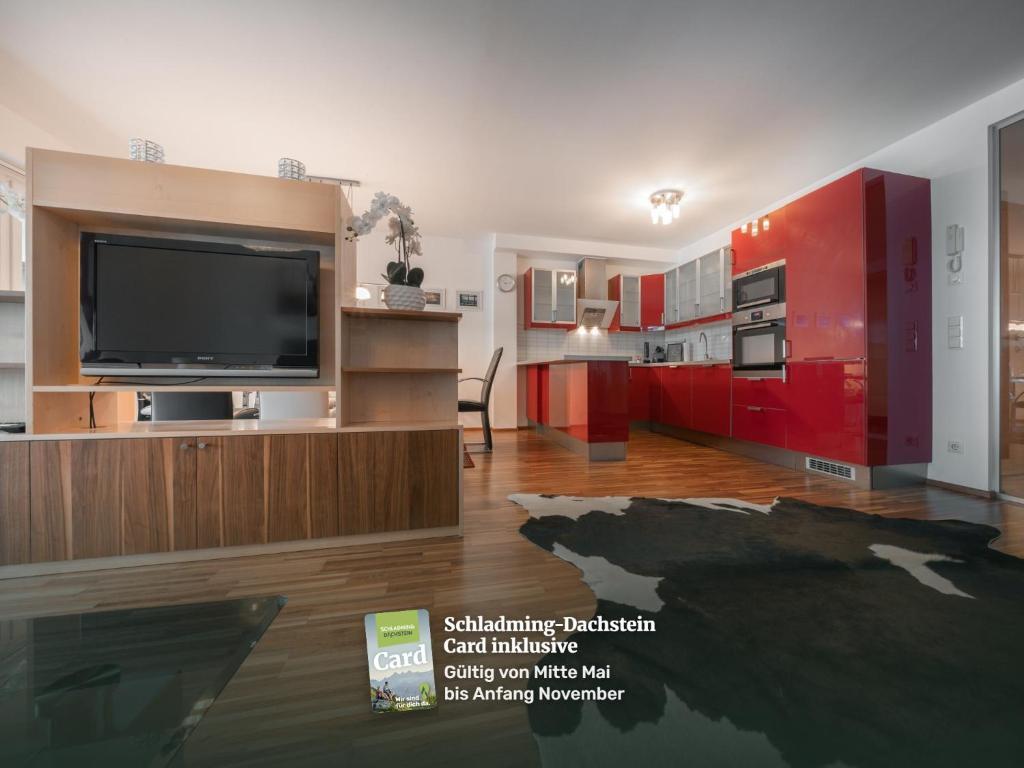 a living room with red cabinets and a flat screen tv at Appartementhaus Crystal by Schladming-Appartements in Schladming