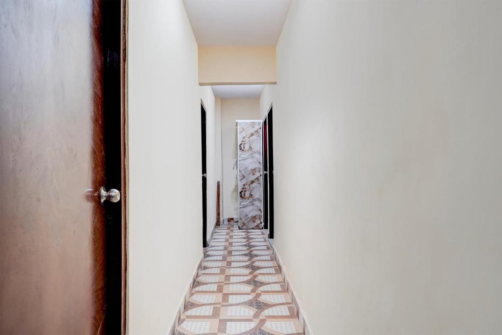 a hallway with white walls and a floor with a staircase at Hotel O Shivay Inn Ayodhaya Bypass Road in Bhopal