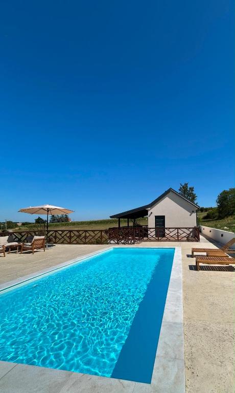 a blue swimming pool in front of a house at SoL Zlatni koreni in Palanka