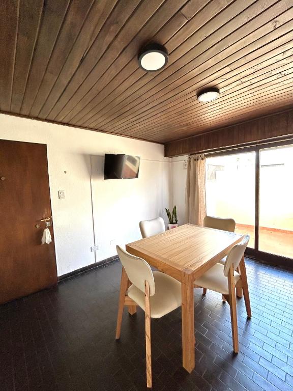 a dining room with a wooden table and chairs at Magnolia Tempo in Esquel