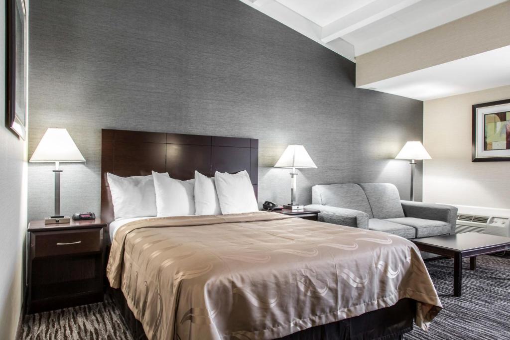 a hotel room with a bed and a chair at Danbury Inn & Suites in Danbury