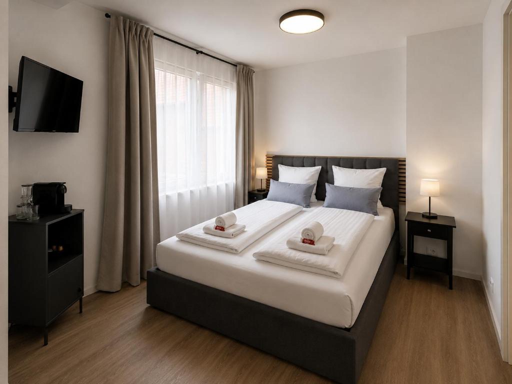 a bedroom with a large bed with two towels at Boutique Hotel Celler Altstadt - 24h Check-in in Celle