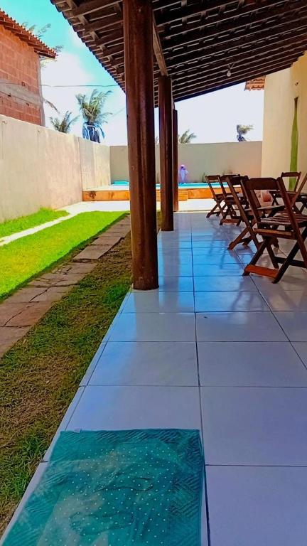 a patio with chairs and a mat on the floor at BELL MAR CHALéS 05 in Luis Correia