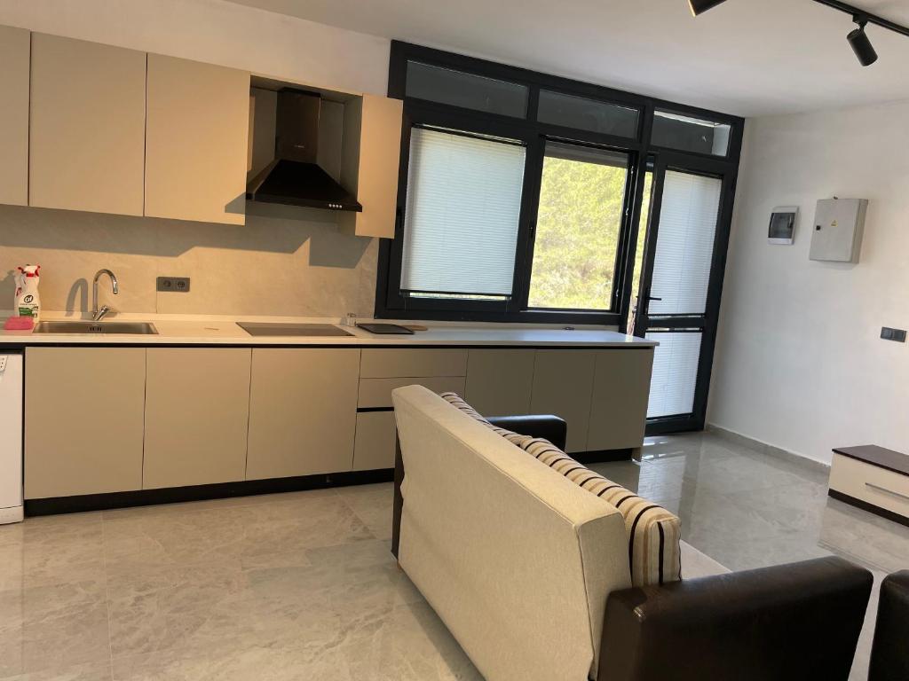 a kitchen with a sink and a couch in a room at Oksijen in Urla