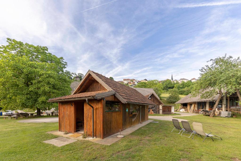 a small building with two chairs in a yard at 3 Rivers Beehive cabin on a farm in Radovljica