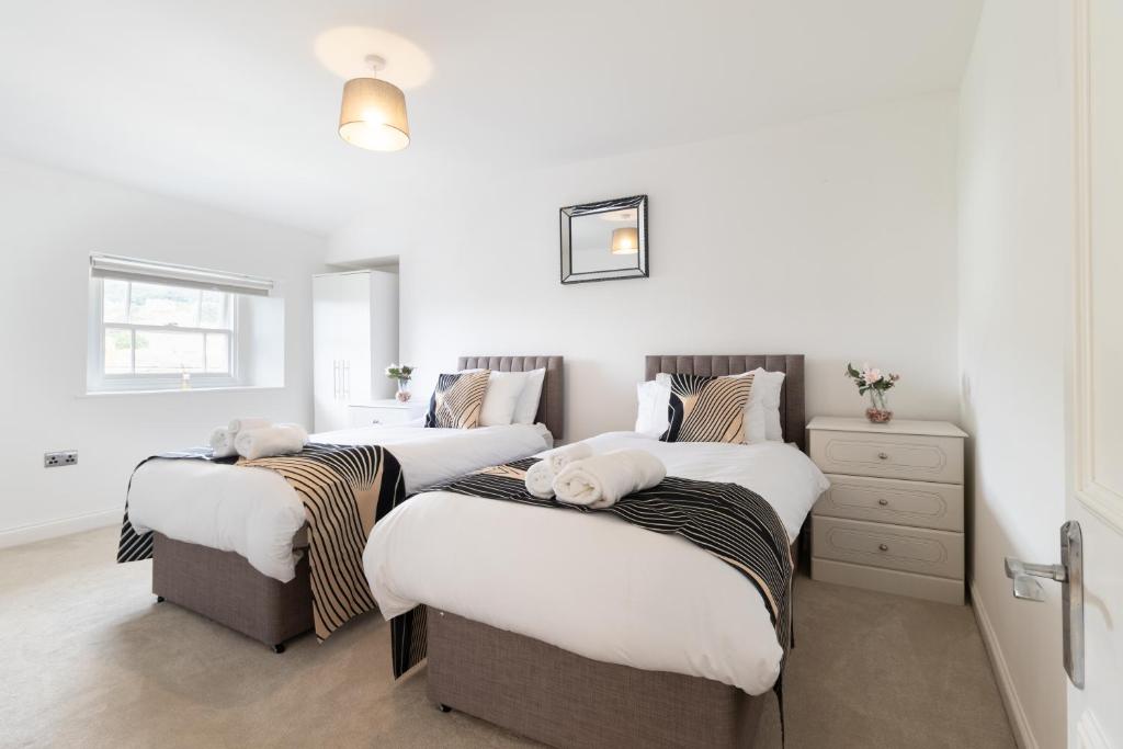 three beds in a room with white walls at Executive 2BR Business & Contractor Stay in Weston-super-Mare