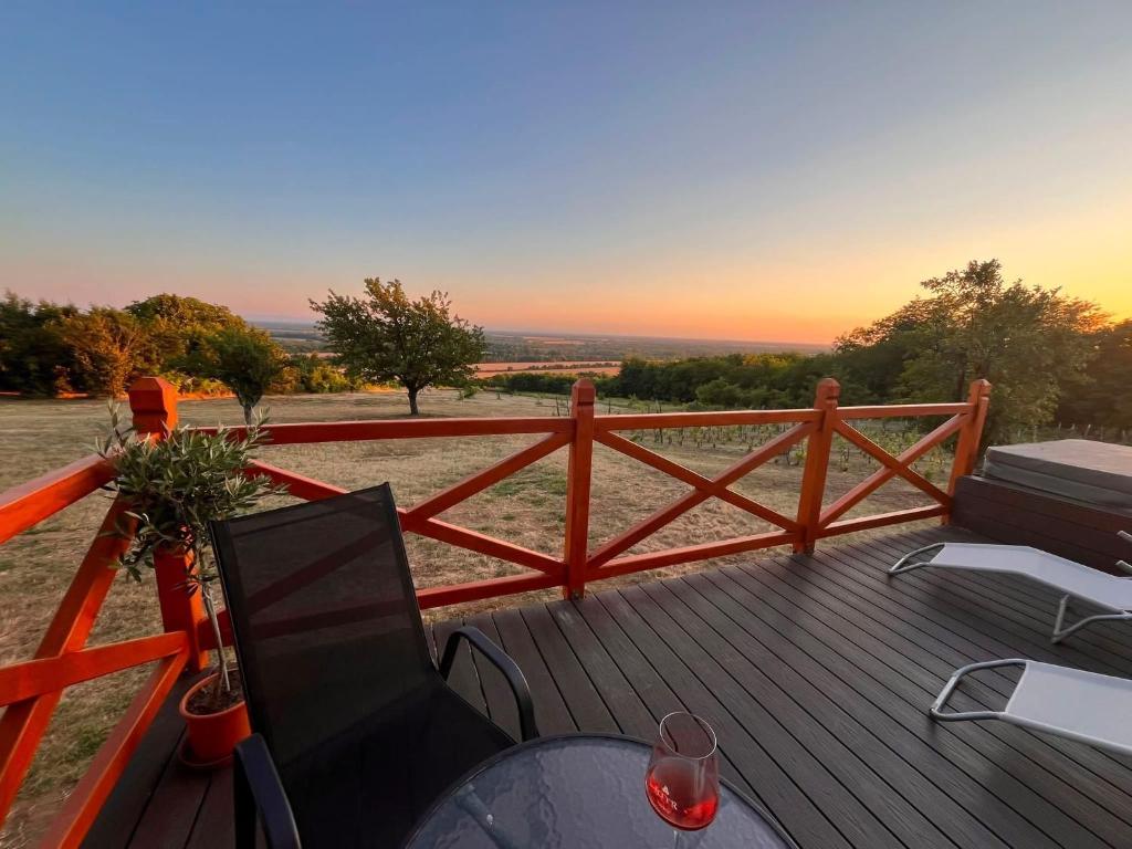 a deck with a table and chairs and a fence at Odavagyok Vendégház in DiÃ³sviszlÃ³