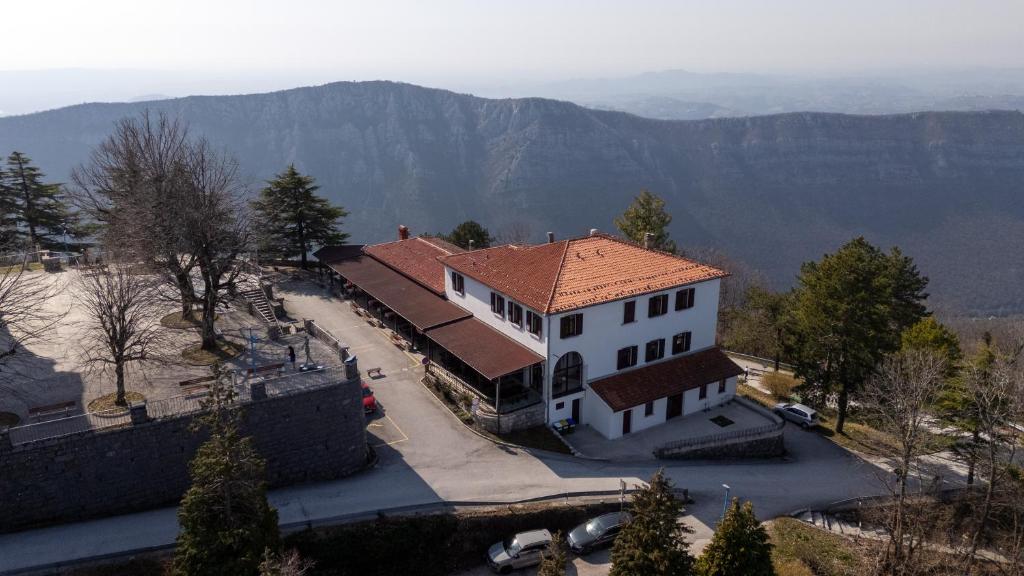 a large white building with a red roof at Guesthouse Rajski okusi Sveta Gora in Solkan