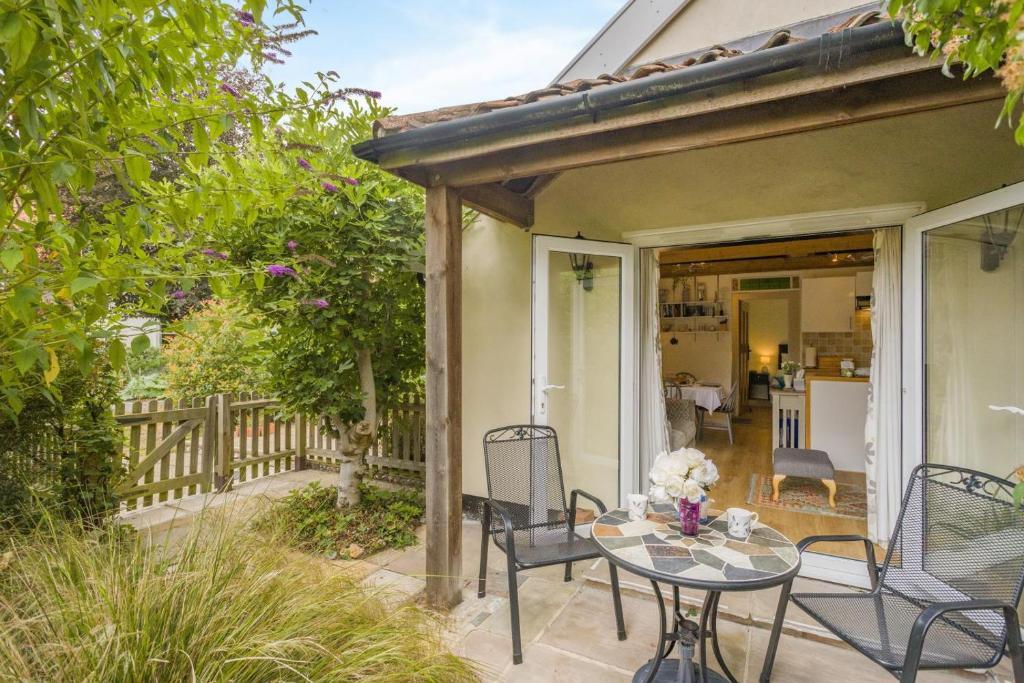 a patio with a table and chairs on a porch at 1 Bed in Snape oc-9tts in Snape