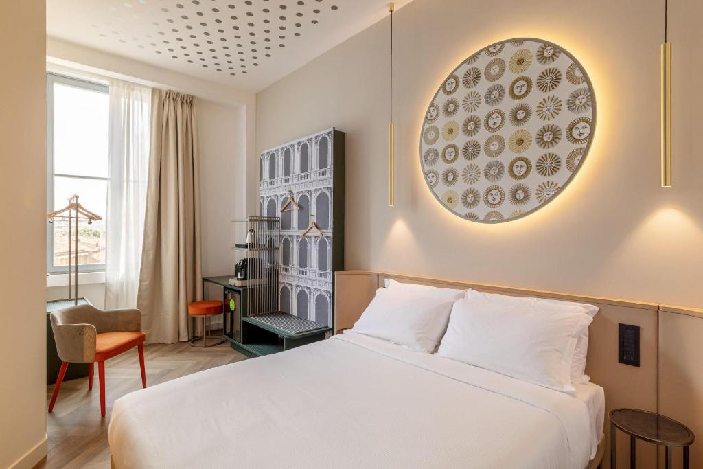 a hotel room with a white bed and a desk at B&B HOTEL Milano Duomo Velasca in Milan