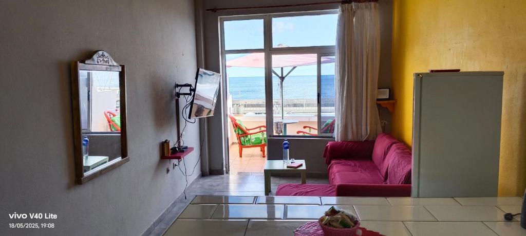 a living room with a pink couch and a window at Lindas Vistas in Tías