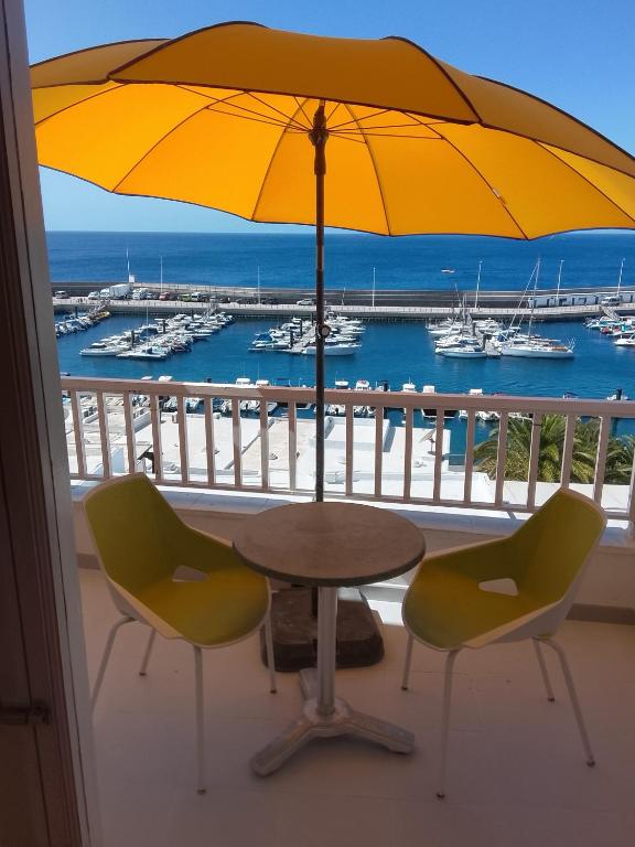 a table with two chairs and an umbrella on a balcony at Rent Vacancy Arcoiris in Tías