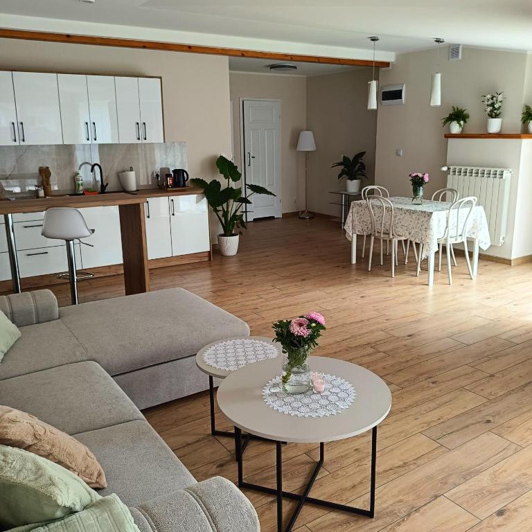 a living room with a couch and a table with flowers on it at Apartamenty 40 in Ciechocinek
