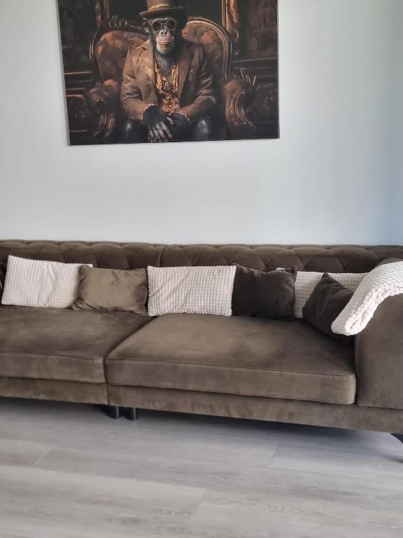 a brown couch sitting in a living room with a painting at Apartment Affengrün in Weyhausen