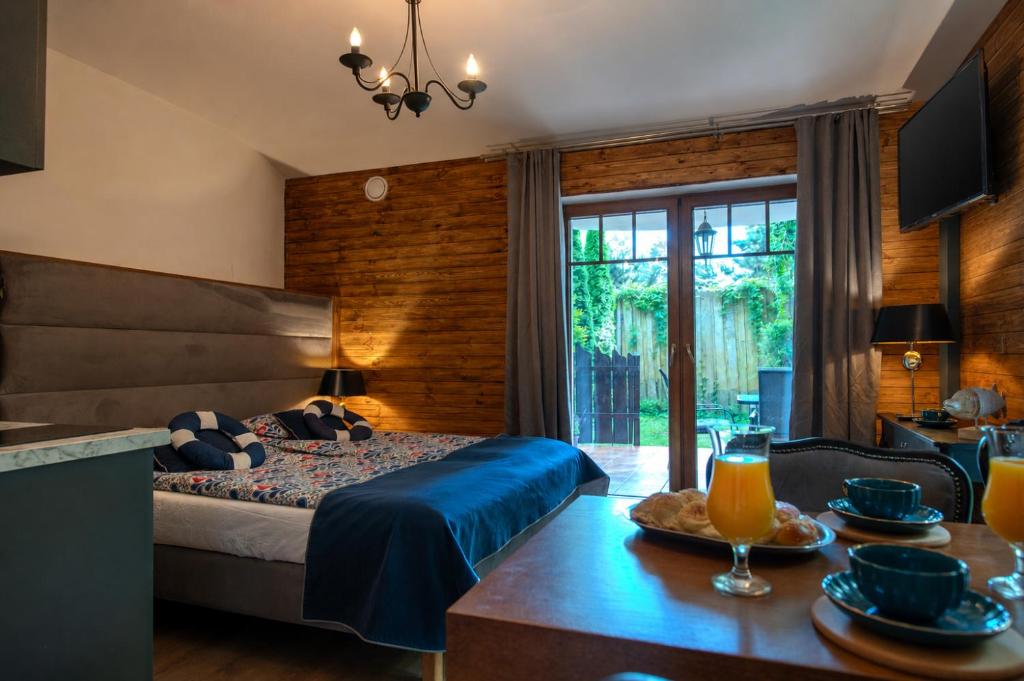 a bedroom with a bed and a table with food on it at Detlafówka Kaszubski Resort in Dębki
